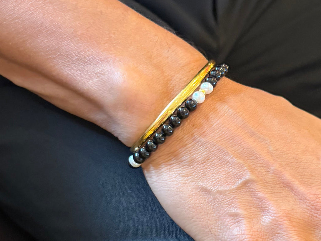 The Luminary black pearl bracelet worn while seated