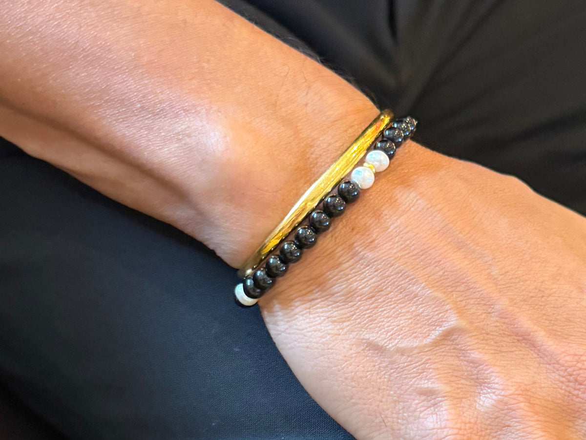 The Luminary black pearl bracelet worn while seated
