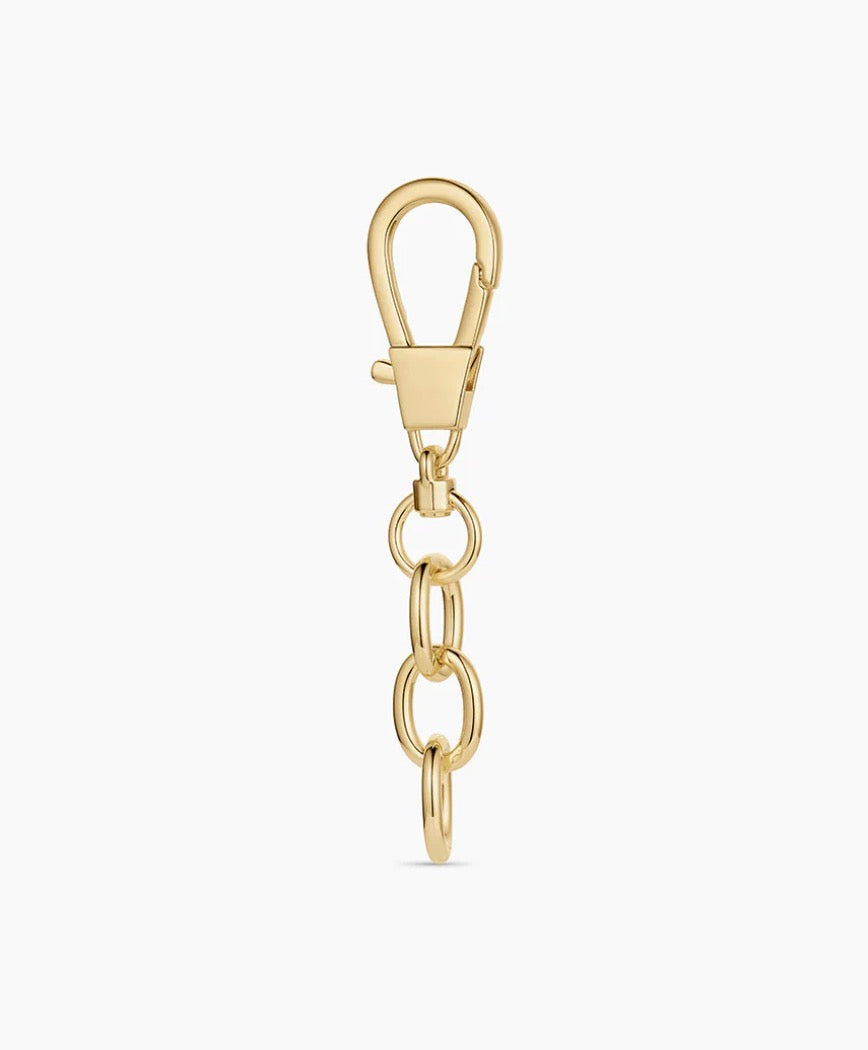 Custom gold-tone bag charm with a personalized charm arrangement