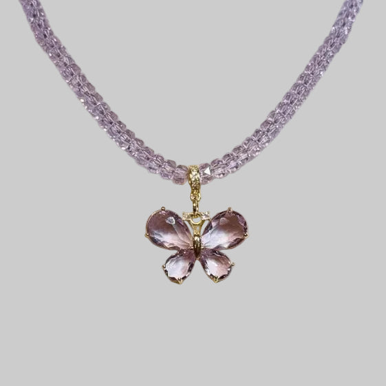 Close-up of a lavender butterfly pendant and crystal beads
